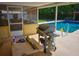 Inviting screened poolside patio with outdoor grill, adjacent to a sparkling pool, ideal for outdoor gatherings at 1 Cosmos Dr, Orlando, FL 32807