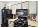 Close up shot of kitchen featuring black appliances, and mosaic backsplash and bright cabinetry at 1005 Love Ln # 25, Apopka, FL 32703