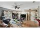 Open living room featuring hardwood floors, ceiling fan, glass table and access to the outdoor patio at 1005 Love Ln # 25, Apopka, FL 32703