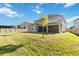 Large backyard featuring green lawn, privacy fence and view of home's rear elevation at 10626 Bonne Chance Dr, Orlando, FL 32832