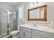 Modern bathroom featuring a glass-enclosed shower, gray vanity, and large framed mirror at 10626 Bonne Chance Dr, Orlando, FL 32832