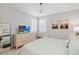 Comfortable bedroom features a TV, beach-themed art, light colored walls and shuttered windows at 10626 Bonne Chance Dr, Orlando, FL 32832