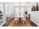 Elegant dining room featuring a white table with seating for eight, a modern chandelier, and hardwood floors at 10626 Bonne Chance Dr, Orlando, FL 32832