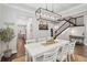 Stylish dining room with hardwood floors, a modern chandelier, a white table with chairs, and a wine rack at 10626 Bonne Chance Dr, Orlando, FL 32832