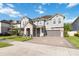 Beautiful two-story home with a gray exterior, stone accents, a paver driveway, and lush green lawn at 10626 Bonne Chance Dr, Orlando, FL 32832