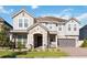 Stunning two-story home featuring a stone facade, gray exterior, and well-manicured landscaping at 10626 Bonne Chance Dr, Orlando, FL 32832