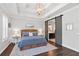 Charming main bedroom featuring barn door to bathroom, decorative lighting, and tray ceiling at 10626 Bonne Chance Dr, Orlando, FL 32832