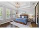 Serene bedroom with neutral colors, tray ceiling, and plantation shutters at 10626 Bonne Chance Dr, Orlando, FL 32832