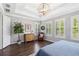 Bright main bedroom boasting tray ceiling, decorative lighting, wood floors and plantation shutters at 10626 Bonne Chance Dr, Orlando, FL 32832