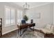 Bright and airy home office featuring plantation shutters, modern lighting, neutral colors, and hardwood floors at 10626 Bonne Chance Dr, Orlando, FL 32832