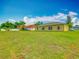 Spacious backyard of home featuring a large green lawn and rear view of the home at 107 Carlisle Ct, Kissimmee, FL 34758