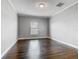 Bright bedroom featuring wood floors, a window with blinds, and neutral paint at 107 Carlisle Ct, Kissimmee, FL 34758