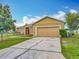 Appealing single-level home featuring a lush green lawn, a wide driveway, and a roomy attached two-car garage at 107 Carlisle Ct, Kissimmee, FL 34758
