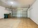 Spacious garage with tiled floor, garage door, overhead lighting, and trash cans at 107 Carlisle Ct, Kissimmee, FL 34758