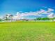 Expansive, green vacant lot with blue sky and scattered clouds in the background at 107 Carlisle Ct, Kissimmee, FL 34758