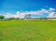Expansive, green vacant lot with blue sky and scattered clouds in the background at 107 Carlisle Ct, Kissimmee, FL 34758