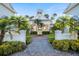Elegant clubhouse entrance with lush tropical landscaping and inviting walkway at 112 Southern Pecan Cir # 201, Winter Garden, FL 34787