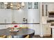 Kitchen dining area with white cabinets, stainless steel appliances, and a modern light fixture at 112 Southern Pecan Cir # 201, Winter Garden, FL 34787