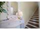 Light and bright foyer area with elegant console table and decorative mirror near the stairs at 112 Southern Pecan Cir # 201, Winter Garden, FL 34787