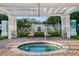 Relaxing hot tub area with seating, lush landscaping, and a serene setting under a shaded structure at 112 Southern Pecan Cir # 201, Winter Garden, FL 34787