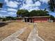 Single story home with small covered porch and long driveway needing repairs in an established neighborhood at 122 Laurel Dr, Sanford, FL 32773