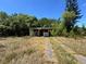 Single-story home featuring overgrown vegetation and driveway leading up to the house at 122 Laurel Dr, Sanford, FL 32773