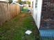 Backyard view of grass area alongside the home and wooden fence at 135 Bob Thomas Cir, Sanford, FL 32771