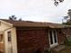 Back exterior view featuring brick and siding, with double doors and a brown shingle roof at 135 Bob Thomas Cir, Sanford, FL 32771
