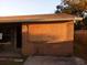 Exterior shot showing boarded window on a tan stucco wall with brown roof and back yard at 135 Bob Thomas Cir, Sanford, FL 32771