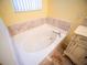 A soothing bathtub with marble accents offers a luxurious space for relaxation and comfort at 1870 Vale Dr, Clermont, FL 34711