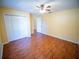Bedroom features wood floors, ceiling fan, and double-door closet for ample storage space at 1870 Vale Dr, Clermont, FL 34711
