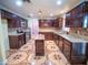 Spacious kitchen features granite countertops, dark wood cabinets, stainless steel appliances and tiled floors at 1870 Vale Dr, Clermont, FL 34711
