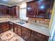 Close-up of a well-appointed kitchen with granite counters, dark wood cabinets, and stainless steel sink at 1870 Vale Dr, Clermont, FL 34711