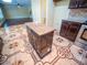 Kitchen island with a granite countertop and storage, surrounded by decorative tiled floor at 1870 Vale Dr, Clermont, FL 34711