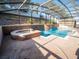 This screened-in pool area is enhanced by a spa and decorative waterfall features at 1870 Vale Dr, Clermont, FL 34711
