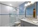 Bathroom featuring modern vanity, large mirror, glass enclosed shower, and gray-blue walls at 194 Heron Bay Cir, Lake Mary, FL 32746