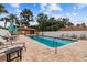 Relaxing community pool area with lounge chairs, tables, umbrellas, and surrounding greenery at 194 Heron Bay Cir, Lake Mary, FL 32746