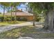 Inviting home featuring mature trees, a circular driveway, lush landscaping, and a two-car garage at 194 Heron Bay Cir, Lake Mary, FL 32746