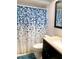 Functional bathroom showcasing a vanity with sink and a toilet with patterned shower curtain at 19430 Sw 100Th Loop, Dunnellon, FL 34432