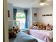 Inviting ' bedroom featuring two twin beds, colorful decor, and a window seat at 19430 Sw 100Th Loop, Dunnellon, FL 34432