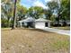 Well-maintained single-story home with a spacious driveway and mature trees at 19430 Sw 100Th Loop, Dunnellon, FL 34432
