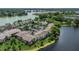 Scenic aerial view showcasing condos nestled along a lake, with lush landscaping and ample parking at 200 Maitland Ave # 153, Altamonte Springs, FL 32701