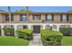 Condo exterior with manicured hedges, a pathway to the front door, and muted brown and white facade at 200 Maitland Ave # 153, Altamonte Springs, FL 32701