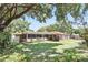Backyard view featuring a screened-in lanai, a well-maintained lawn, and mature trees offering ample shade at 2024 Linden Road, Winter Park, FL 32792