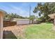View of the backyard featuring a white fence, mature trees, and a grassy lawn at 2024 Linden Road, Winter Park, FL 32792