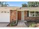 Close-up showcasing the charming brick facade and front door with brick paver walkway and landscaped accents at 2024 Linden Road, Winter Park, FL 32792