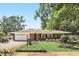 Charming brick home with a well-manicured lawn, lush landscaping, and a cozy bench, creating inviting curb appeal at 2024 Linden Road, Winter Park, FL 32792