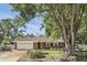 Attractive brick home with manicured lawn, complemented by a brick driveway and mature trees, creating a welcoming ambiance at 2024 Linden Road, Winter Park, FL 32792