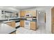 Well-lit kitchen with light wood cabinets and white appliances, and a window with natural light at 2024 Linden Road, Winter Park, FL 32792