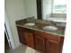 Bathroom vanity with double sinks, granite countertop, brown cabinets, and a large mirror at 2737 Monticello Way, Kissimmee, FL 34741